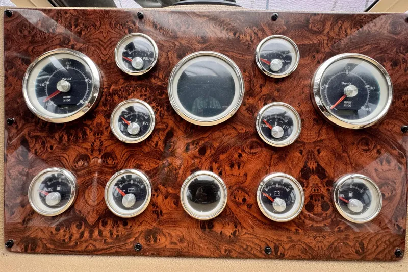  Yacht Photos Pics Dashboard of a 2006 Meridian 490 Pilothouse with multiple gauges and wood finish.