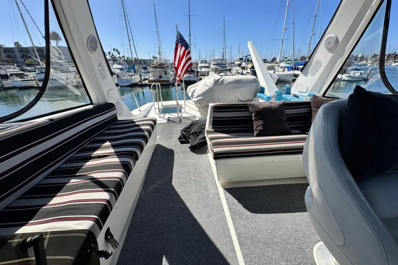  Yacht Photos Pics 2006 Meridian 490 Pilothouse interior with striped seating, docked in a sunny marina.