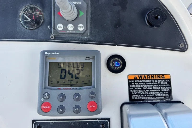  Yacht Photos Pics Control panel of a 2006 Meridian 490 Pilothouse with Raymarine display and warning label.