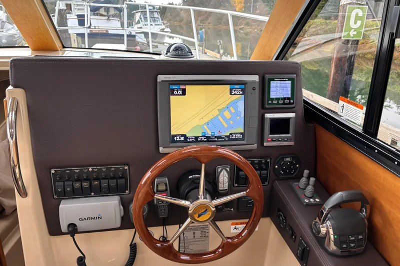 "salt Shaker" Yacht Photos Pics 2013 Cutwater C-28 helm with navigation screens, wooden steering wheel, and control panel.