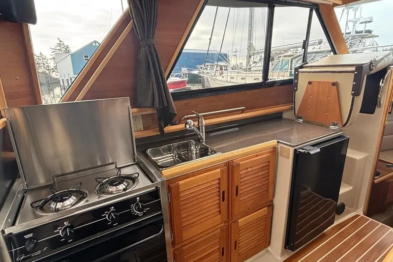 "salt Shaker" Yacht Photos Pics 2013 Cutwater C-28 boat interior kitchen with stove, sink, and wooden cabinets.