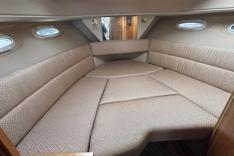 "salt Shaker" Yacht Photos Pics 2013 Cutwater C-28 cabin interior with beige patterned upholstery and small windows.