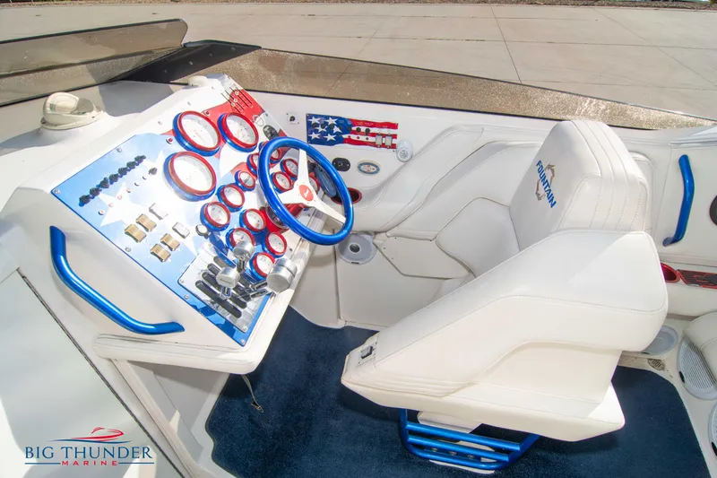  Yacht Photos Pics Cockpit of a 2005 Fountain 42 Executioner boat with white and blue interior.