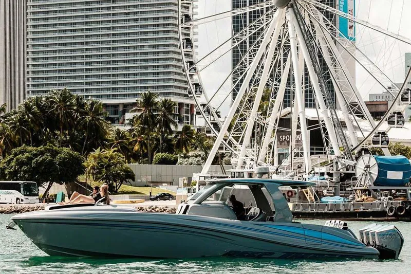  Yacht Photos Pics 2027 Deep Impact 399 Fwd Cabin boat cruising near a Ferris wheel and cityscape.