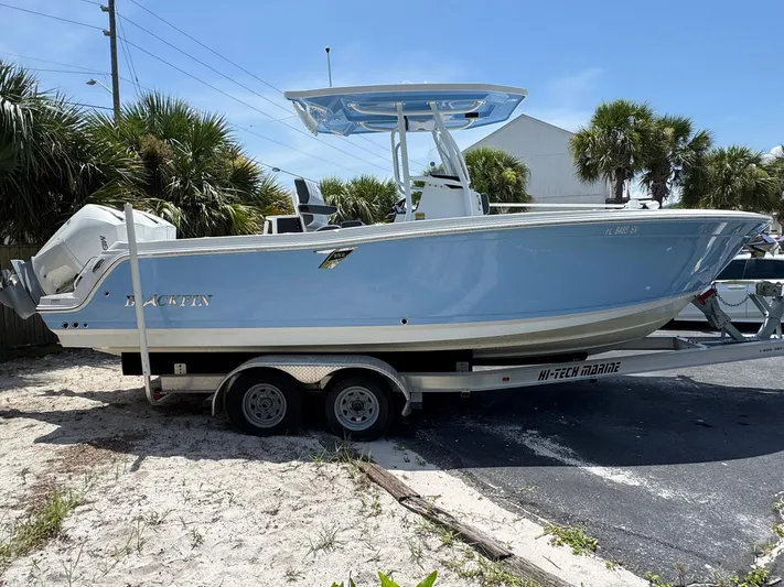  Yacht Photos Pics 2021 Blackfin 252 CC boat on trailer, parked near palm trees.