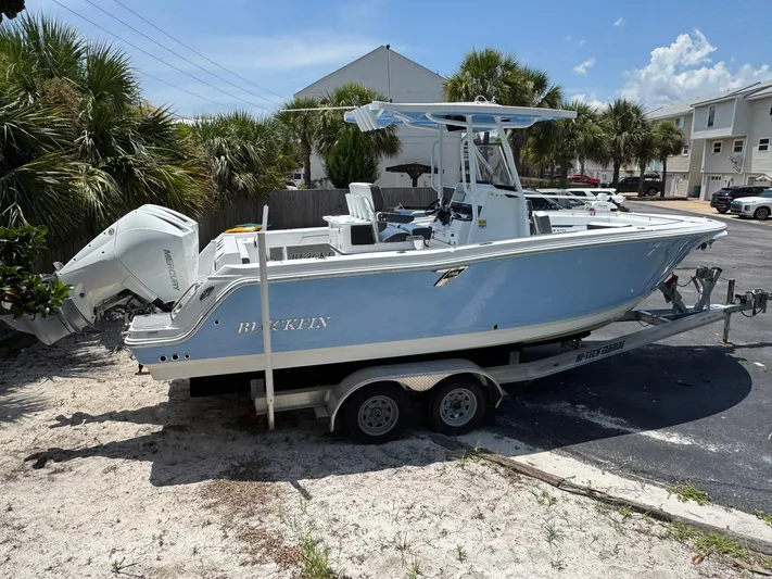  Yacht Photos Pics 2021 Blackfin 252 CC boat on trailer, parked near palm trees and buildings.
