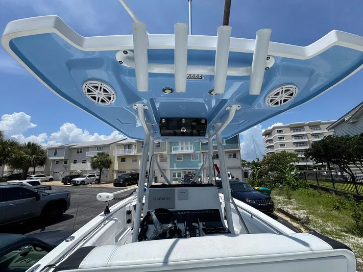  Yacht Photos Pics 2021 Blackfin 252 CC boat with blue canopy, parked in a residential area.