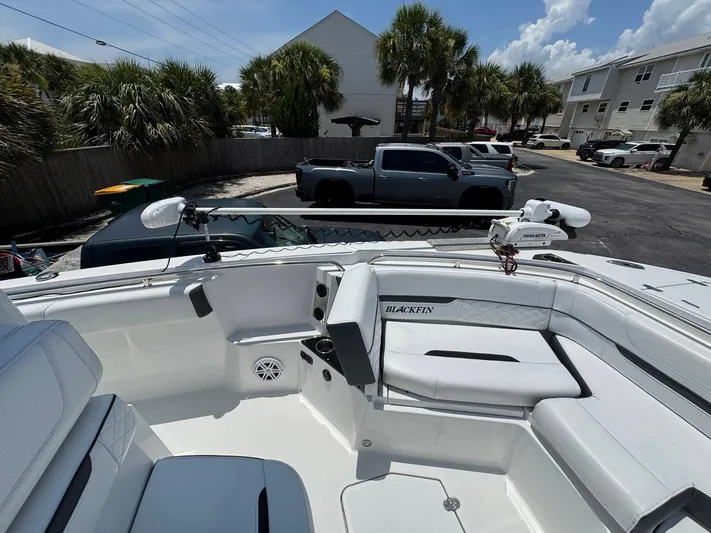  Yacht Photos Pics 2021 Blackfin 252 CC boat interior with seating, parked in a lot with palm trees.