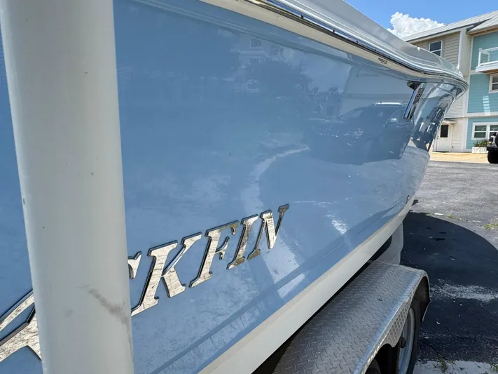  Yacht Photos Pics 2021 Blackfin 252 CC boat on trailer, shiny blue hull, parked near buildings.