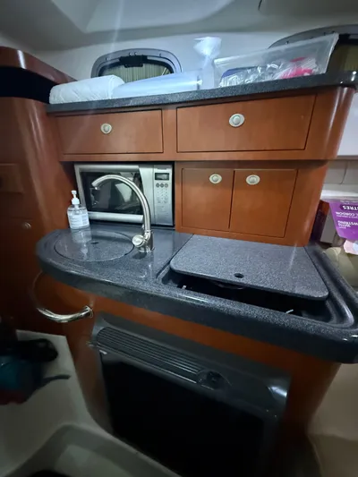  Yacht Photos Pics 2006 Boston Whaler 305 Conquest kitchen area with sink, microwave, and storage cabinets.
