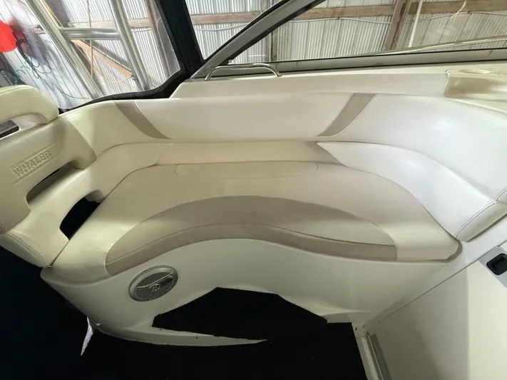  Yacht Photos Pics 2006 Boston Whaler 305 Conquest interior seating with white upholstery and speaker detail.