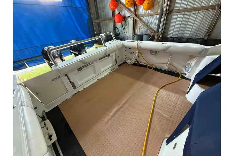  Yacht Photos Pics 2006 Boston Whaler 305 Conquest boat interior with Mercury engines in a storage facility.