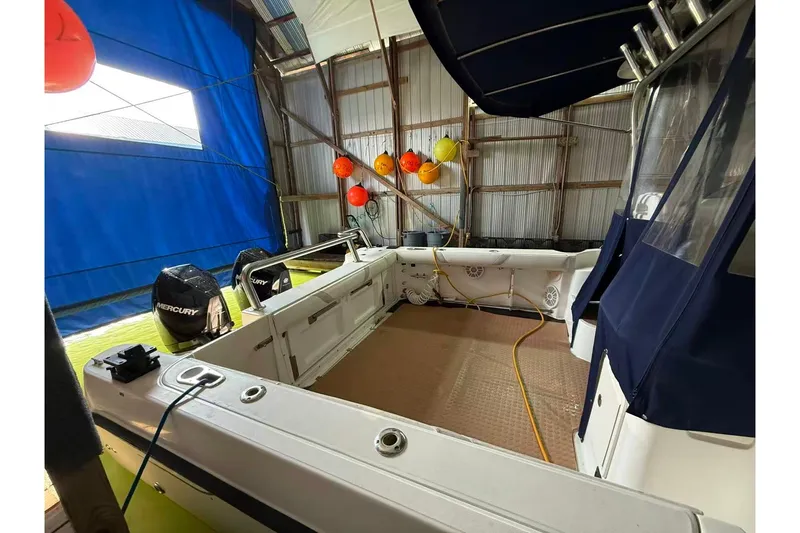  Yacht Photos Pics 2006 Boston Whaler 305 Conquest boat interior with Mercury engines in a covered storage area.