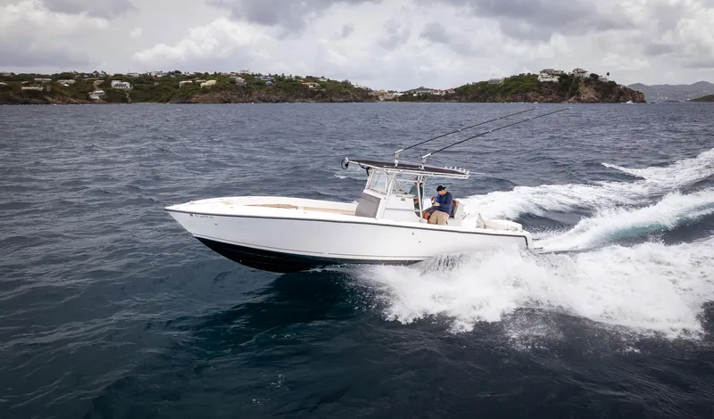  Yacht Photos Pics 2006 SeaVee 34 CC boat cruising on ocean with fishing rods, near coastal landscape.