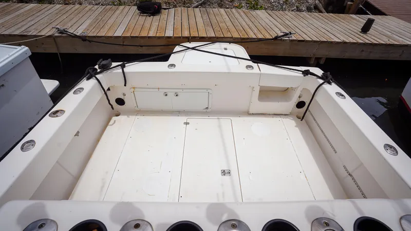  Yacht Photos Pics 2006 SeaVee 34 CC boat deck with rod holders, docked at wooden pier.