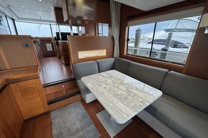 Balena Yacht Photos Pics Interior of 2015 Beneteau Swift Trawler 50 with marble table and gray seating.
