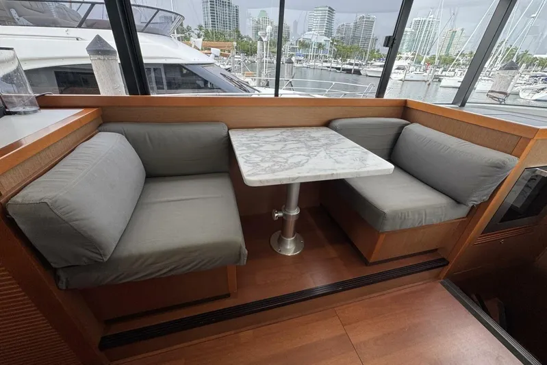 Balena Yacht Photos Pics Interior of 2015 Beneteau Swift Trawler 50 with cozy seating and marble table.