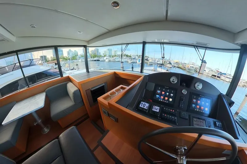 Balena Yacht Photos Pics Interior view of 2015 Beneteau Swift Trawler 50 helm with marina backdrop.