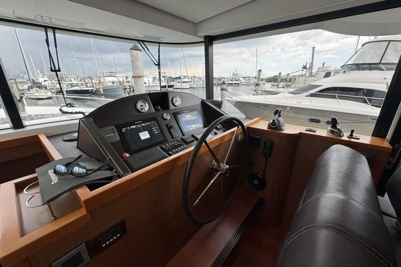 Balena Yacht Photos Pics Interior helm of 2015 Beneteau Swift Trawler 50 at marina, featuring navigation controls.