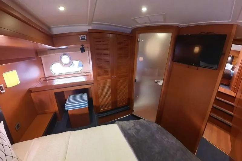 Balena Yacht Photos Pics 2015 Beneteau Swift Trawler 50 cabin interior with wood finish, desk, and TV.