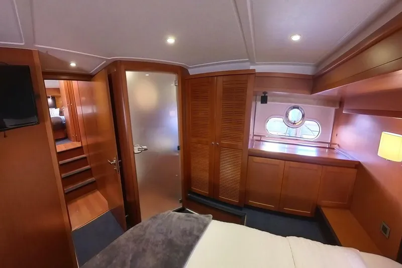 Balena Yacht Photos Pics 2015 Beneteau Swift Trawler 50 interior cabin with wood finish and porthole window.