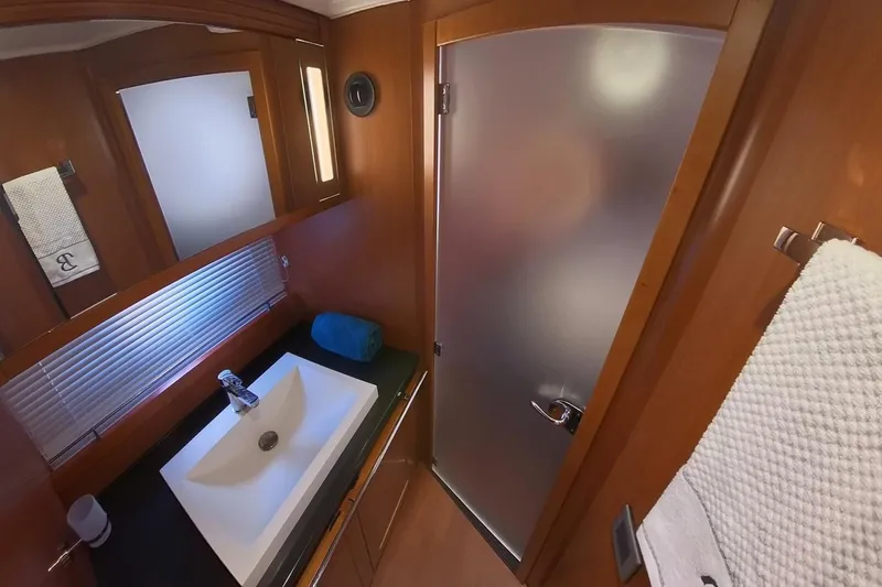 Balena Yacht Photos Pics Luxurious bathroom in 2015 Beneteau Swift Trawler 50 with modern sink and frosted glass door.