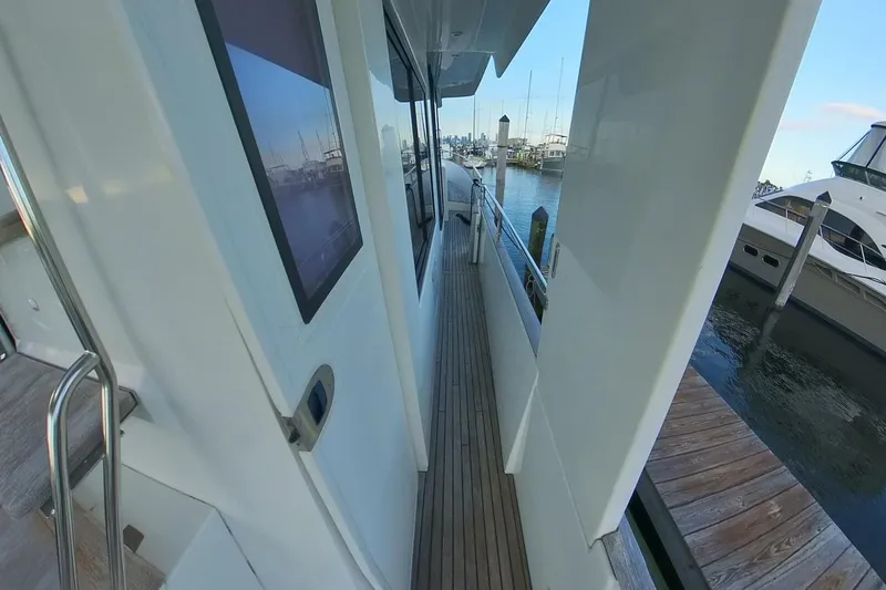 Balena Yacht Photos Pics 2015 Beneteau Swift Trawler 50 side deck view at marina, showcasing sleek design and wood finish.