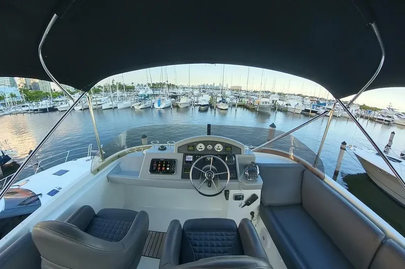 Balena Yacht Photos Pics 2015 Beneteau Swift Trawler 50 helm view at marina, showcasing luxury seating and controls.