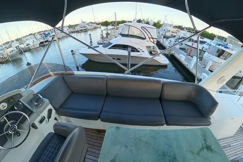 Balena Yacht Photos Pics 2015 Beneteau Swift Trawler 50 interior with marina view, featuring seating and helm station.