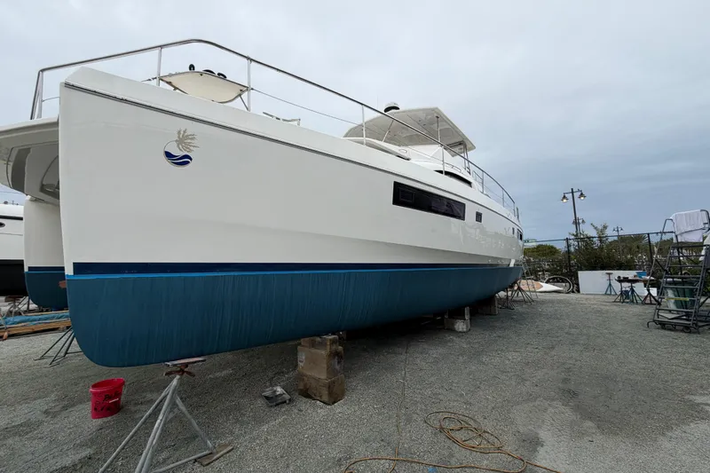  Yacht Photos Pics 2016 Leopard 51 Powercat yacht on dry dock, white hull with blue trim, overcast sky.