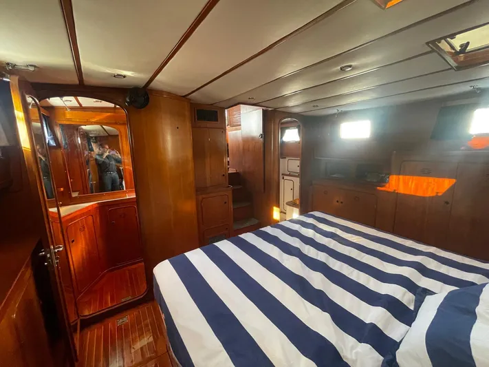 Southerly Yacht Photos Pics Luxurious 1990 Lyman-Morse 52 yacht interior with wood paneling and striped bedding.