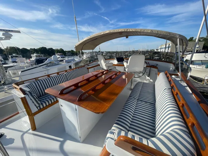 Southerly Yacht Photos Pics Luxurious 1990 Lyman-Morse 52 yacht with striped seating and polished wood table.
