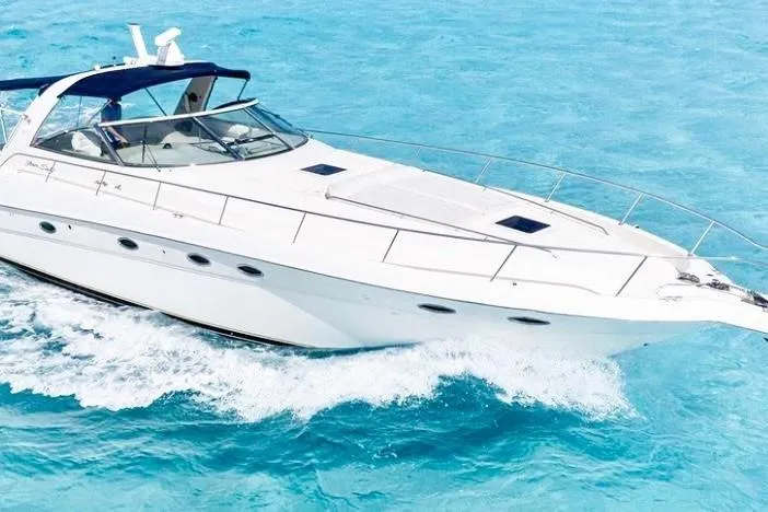 Nauti Nauti Yacht Photos Pics 2000 Searay 460 Sundancer cruising on clear blue water.