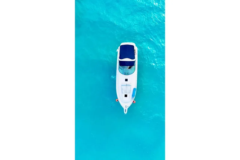 Nauti Nauti Yacht Photos Pics Aerial view of 2000 Searay 460 Sundancer yacht on clear turquoise water.