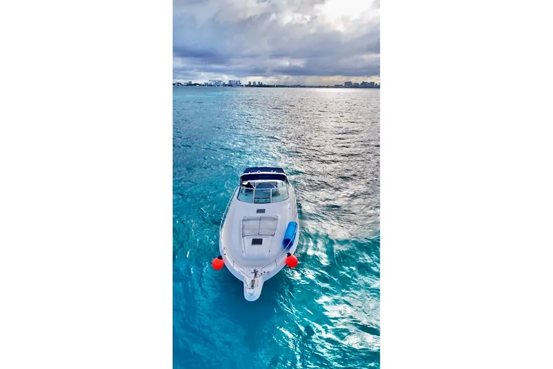 Nauti Nauti Yacht Photos Pics 2000 Searay 460 Sundancer yacht on vibrant blue ocean under cloudy sky.