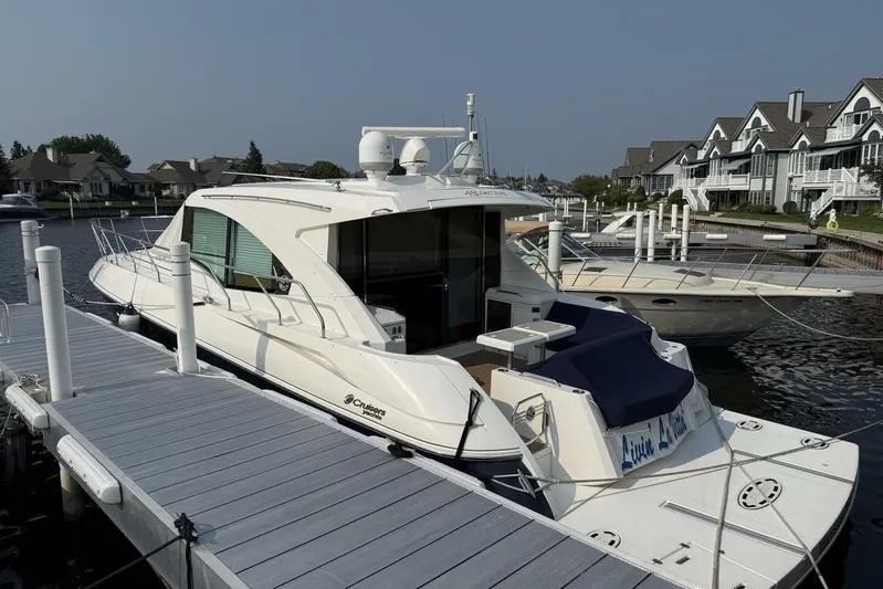  Yacht Photos Pics 2013 Cruisers Yachts Cantius docked at marina, surrounded by waterfront homes.