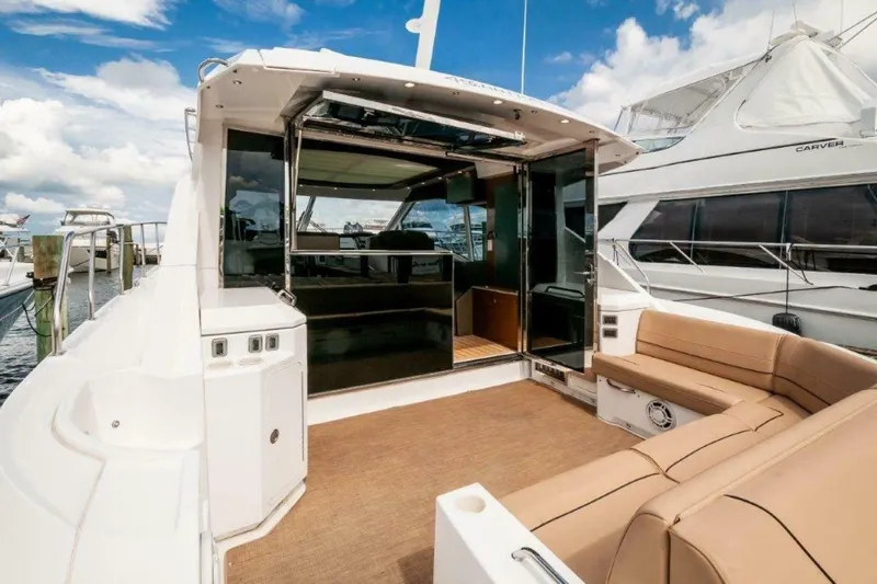  Yacht Photos Pics 2013 Cruisers Yachts Cantius with spacious deck and luxurious seating, docked under blue skies.