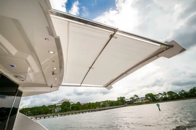  Yacht Photos Pics 2013 Cruisers Yachts Cantius with extended awning over water, showcasing luxury design.