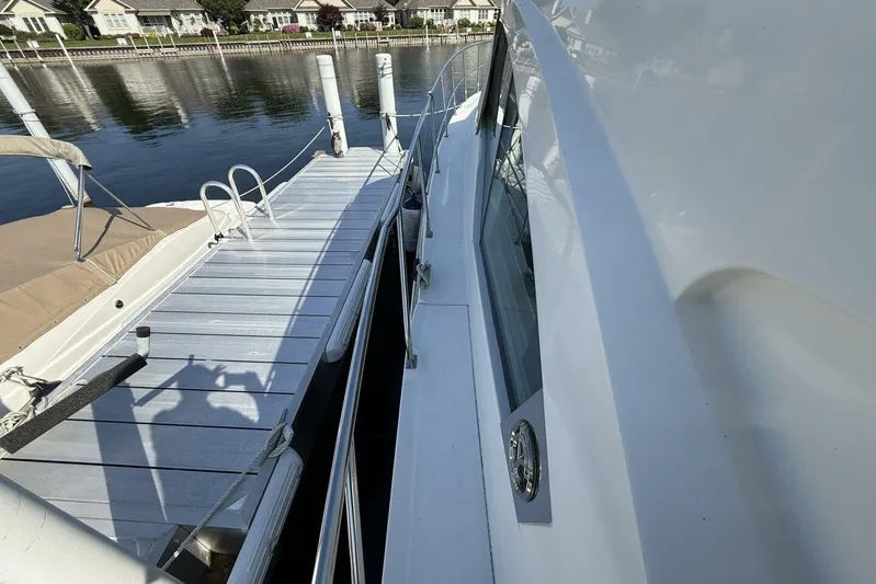  Yacht Photos Pics 2013 Cruisers Yachts Cantius docked beside a wooden pier on a calm waterfront.