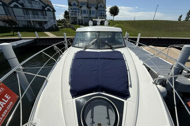  Yacht Photos Pics 2013 Cruisers Yachts Cantius docked near waterfront homes, featuring sleek design and spacious deck.