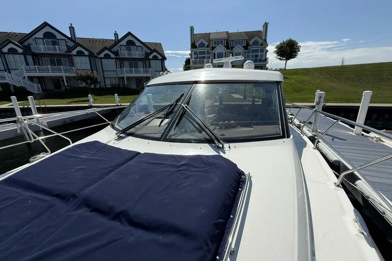  Yacht Photos Pics 2013 Cruisers Yachts Cantius docked near waterfront homes on a sunny day.