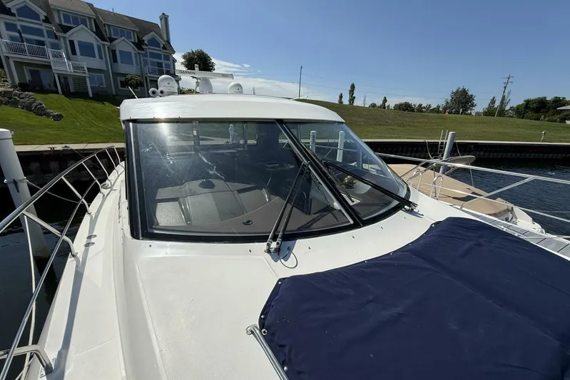  Yacht Photos Pics 2013 Cruisers Yachts Cantius docked near waterfront homes, showcasing sleek design and spacious deck.