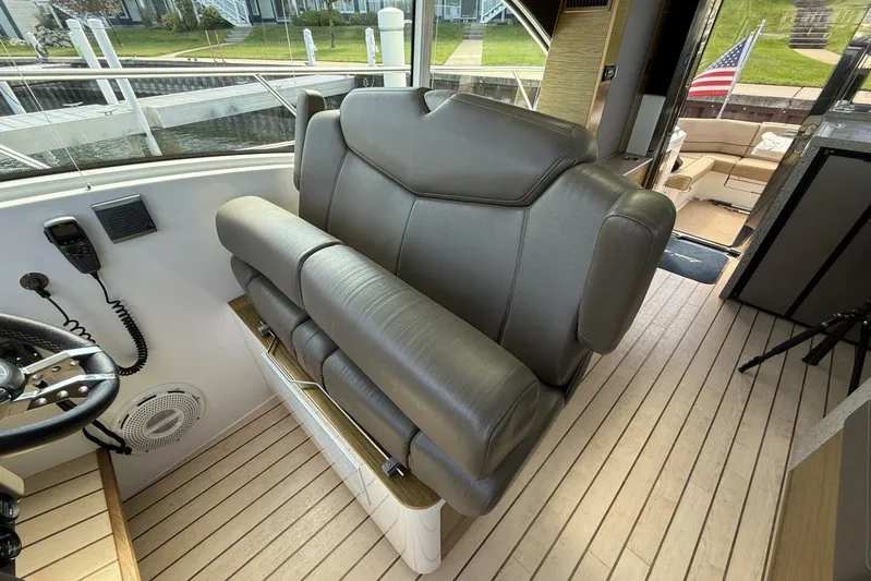 Yacht Photos Pics 2013 Cruisers Yachts Cantius helm seat with leather upholstery and wooden flooring.