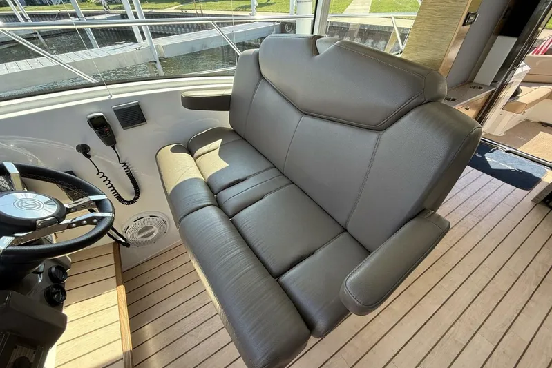  Yacht Photos Pics 2013 Cruisers Yachts Cantius helm seat with steering wheel and communication equipment.