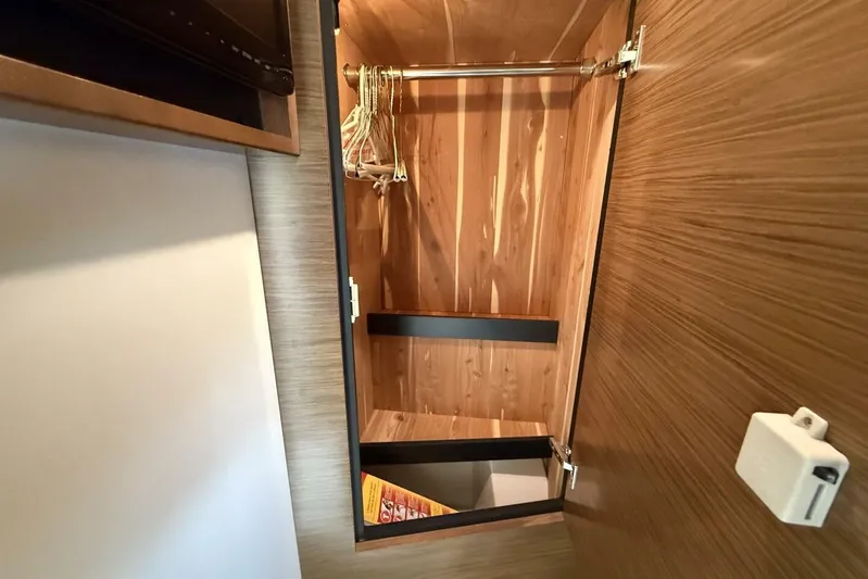  Yacht Photos Pics 2013 Cruisers Yachts Cantius wooden closet interior with hangers and shelving.