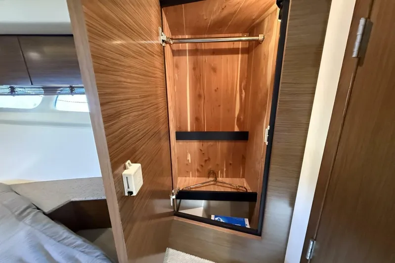  Yacht Photos Pics 2013 Cruisers Yachts Cantius interior closet with wooden finish and hangers.