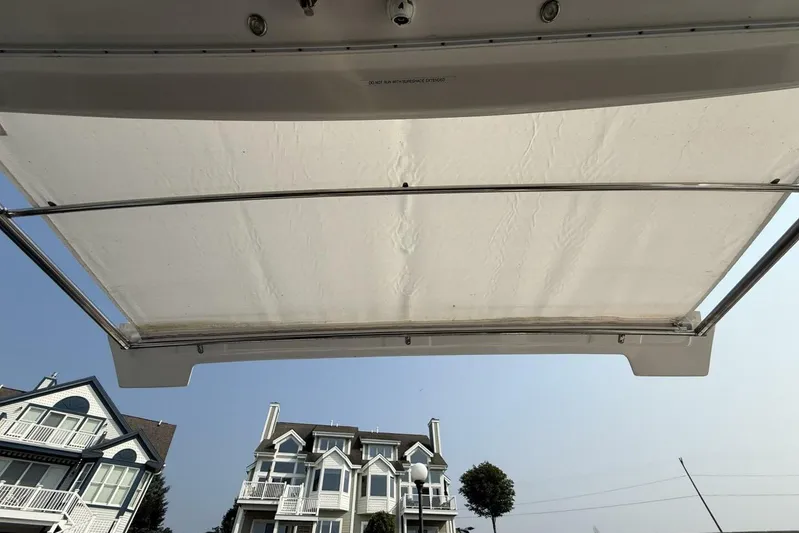  Yacht Photos Pics 2013 Cruisers Yachts Cantius canopy with houses and trees in the background.