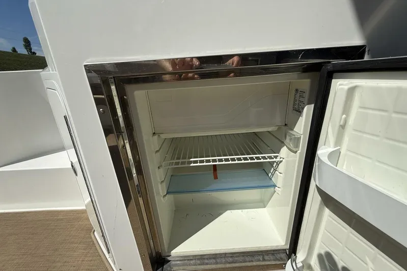  Yacht Photos Pics Open refrigerator on 2013 Cruisers Yachts Cantius, showcasing interior shelving.