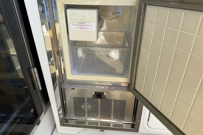  Yacht Photos Pics Open ice maker on 2013 Cruisers Yachts Cantius, showing interior and door.