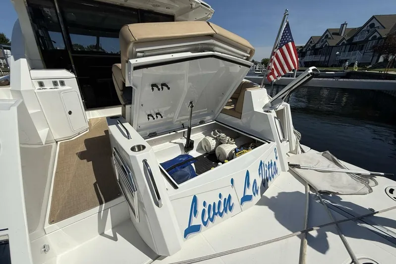  Yacht Photos Pics 2013 Cruisers Yachts Cantius with open storage, American flag, docked near waterfront homes.